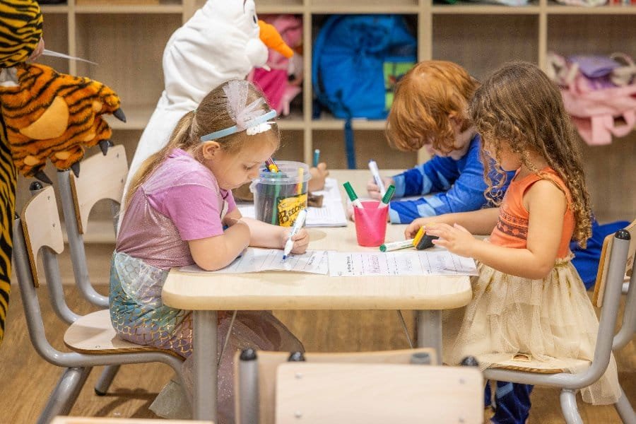 Kindergarten, children writing at a table